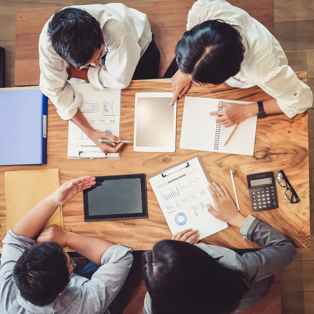 Vista de cima de equipe trabalhando com documentos e tablet sobre a mesa